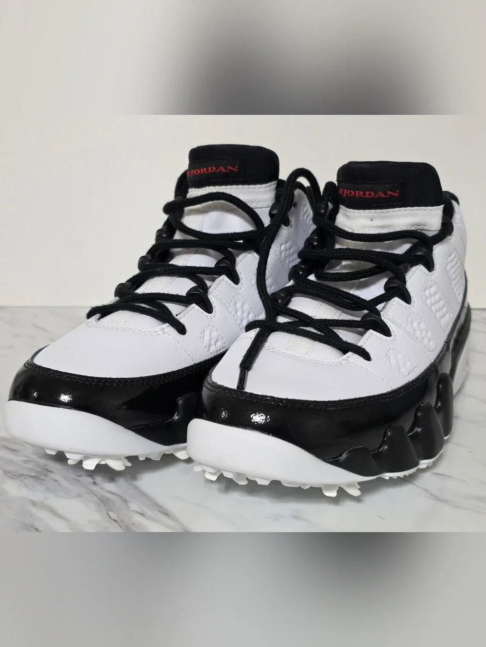 Jordan White and Black Golf Cleats with Red Logo